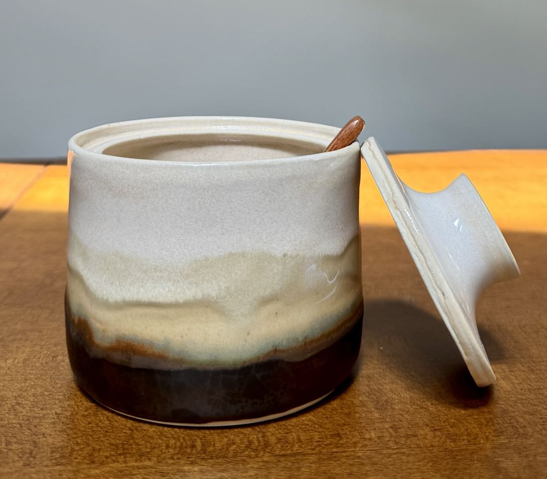 Lidded jar layered in white, oat and iron glazes